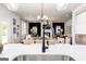 Modern kitchen featuring stainless steel sink and black faucet with an open view to the living and dining area at 608 Belshire Dr, Acworth, GA 30102