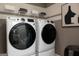 Modern laundry room with front loading washer and dryer and upper shelving at 608 Belshire Dr, Acworth, GA 30102