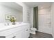 Bright bathroom featuring a double vanity, white cabinets, and shower with green curtain at 502 Regency Trl, Acworth, GA 30102