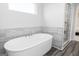 Modern white soaking tub with luxury vinyl plank flooring and a window offering natural light at 502 Regency Trl, Acworth, GA 30102