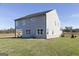 Rear exterior view of home with a sodded backyard and covered patio area at 502 Regency Trl, Acworth, GA 30102