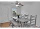 Cozy dining area features wood table with bench seating, a ceiling fan, and natural light at 11367 Vinea Ln, Hampton, GA 30228