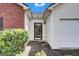 Welcoming front entrance with a glass-paneled door and manicured bushes leading to a two-car garage at 11367 Vinea Ln, Hampton, GA 30228