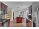 Bright kitchen with red island and cabinets, stainless steel appliances, and adjacent living spaces at 11367 Vinea Ln, Hampton, GA 30228