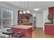 Bright kitchen featuring red cabinets, a central island with seating, and stainless steel appliances at 11367 Vinea Ln, Hampton, GA 30228