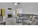 Bright living room with a fireplace, gray sofa, and open access to the dining area at 11367 Vinea Ln, Hampton, GA 30228