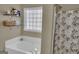 Spacious main bathroom featuring a tub with glass block window and tiled shower at 11367 Vinea Ln, Hampton, GA 30228
