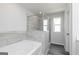Bright bathroom featuring a soaking tub, separate glass shower, and a window providing natural light at 407 Newland Way, Acworth, GA 30102