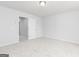Neutral carpeted bedroom featuring a standard ceiling light, white walls, and a doorway to another room at 407 Newland Way, Acworth, GA 30102