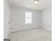 Bright bedroom with neutral carpet, standard ceiling light, and a window providing natural light at 407 Newland Way, Acworth, GA 30102