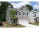 Charming two-story home with gray siding, brick accents, and a two-car garage under a partly cloudy sky at 407 Newland Way, Acworth, GA 30102