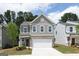 Charming two-story home with gray siding, brick accents, and a two-car garage under a partly cloudy sky at 407 Newland Way, Acworth, GA 30102