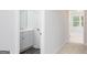 Hallway view to bathroom with modern vanity and tile flooring, and bedroom beyond with natural light at 407 Newland Way, Acworth, GA 30102