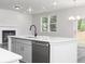 Bright kitchen features a large island with quartz countertops, stainless steel dishwasher, and modern pendant lighting at 407 Newland Way, Acworth, GA 30102