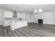 Open concept kitchen with white cabinets, stainless appliances, and fireplace at 407 Newland Way, Acworth, GA 30102