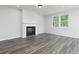 Cozy living room with wood-look flooring, a modern fireplace, and a large window providing natural light at 407 Newland Way, Acworth, GA 30102