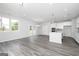 Open-concept living space with wood-look flooring, white walls, and a modern kitchen with stainless steel appliances at 407 Newland Way, Acworth, GA 30102