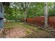 Backyard featuring trees, grassy area, brick patio, and privacy fence at 1772 Martin Se Pl, Smyrna, GA 30080