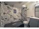 Modern bathroom featuring marbled tiles, a walk-in shower, and black honeycomb floor tiles at 1772 Martin Se Pl, Smyrna, GA 30080