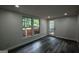 Well-lit living space with hardwood flooring, large windows, and a door leading outside at 1772 Martin Se Pl, Smyrna, GA 30080