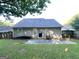 A view of the backyard showing the home's exterior, a small patio, and the lawn at 614 Tramore Ct, Stockbridge, GA 30281