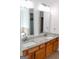 Bathroom featuring double sinks, granite countertop, wood cabinets, and large mirrors at 141 Windward Hills, Mcdonough, GA 30253