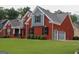 Two-story brick home with a well-manicured lawn, attached garage, and dark shutters at 141 Windward Hills, Mcdonough, GA 30253