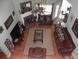 Aerial view of living room with vaulted ceiling, fireplace, leather furniture, and hardwood floors at 141 Windward Hills, Mcdonough, GA 30253