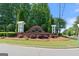 Entrance to Orchard Park featuring brick signage, mature landscaping, and green grass at 385 Orchard Land, Covington, GA 30014