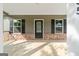 View of the covered front porch showcasing brick accents, a dark front door, and matching window shutters at 385 Orchard Land, Covington, GA 30014