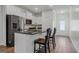 Bright kitchen with white cabinetry, granite counters, stainless steel appliances, and a stylish island with seating at 385 Orchard Land, Covington, GA 30014