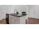 Close-up of the kitchen island featuring granite countertop, stainless steel sink, and bar seating at 385 Orchard Land, Covington, GA 30014