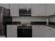 Updated kitchen with black appliances, granite countertops, and white cabinets at 385 Orchard Land, Covington, GA 30014