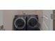 Front-loading washer and dryer set in laundry room with door ajar showing access, and light gray paint at 385 Orchard Land, Covington, GA 30014