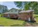 View of the home's backyard featuring a brick exterior, wooden deck, and spacious lawn at 6023 Highway 20 S, Covington, GA 30016