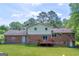 Spacious backyard with a brick two-story home, wooden deck, and lush green lawn at 6023 Highway 20 S, Covington, GA 30016