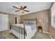 Bedroom featuring wood paneling, a ceiling fan, and an ornate metal bed frame at 6023 Highway 20 S, Covington, GA 30016