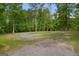 Gravel driveway leading to a home surrounded by lush trees and greenery at 6023 Highway 20 S, Covington, GA 30016
