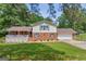 Two-story home with brick and vinyl siding, shutters, a front porch, and an attached garage at 6023 Highway 20 S, Covington, GA 30016