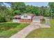 Two-story home with a brick and vinyl exterior, attached garage, long driveway, and manicured lawn at 6023 Highway 20 S, Covington, GA 30016