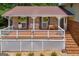 Charming front porch with seating, ferns, white railings, and brick columns and steps at 6023 Highway 20 S, Covington, GA 30016