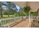 Front porch showcasing wood flooring, ferns, white railings, and wooded views at 6023 Highway 20 S, Covington, GA 30016