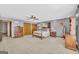 This main bedroom features carpet flooring, gray walls, a ceiling fan and private access to the main bath and wardrobe at 6023 Highway 20 S, Covington, GA 30016