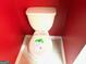 Close-up of standard toilet in a small bathroom space with red walls at 9515 Lakeview Rd, Union City, GA 30291