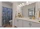 Beach-themed bathroom with double sinks, shower with themed curtain, and decor at 5350 Woodline View Cir, Hoschton, GA 30548