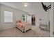 Cozy bedroom featuring a bed, desk, and decor, with plenty of natural light from two large windows at 5350 Woodline View Cir, Hoschton, GA 30548
