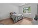 Bright bedroom with hardwood floors, a large window, and neutral decor creating a serene atmosphere at 5350 Woodline View Cir, Hoschton, GA 30548