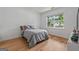 Well-lit bedroom with hardwood floors and a large window offering outdoor views at 5350 Woodline View Cir, Hoschton, GA 30548