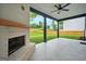 A beautiful covered patio with a painted brick fireplace and a ceiling fan overlooks a large, fenced backyard at 5350 Woodline View Cir, Hoschton, GA 30548