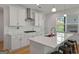 Contemporary kitchen featuring a quartz countertop, stainless steel range hood and bright window at 5350 Woodline View Cir, Hoschton, GA 30548